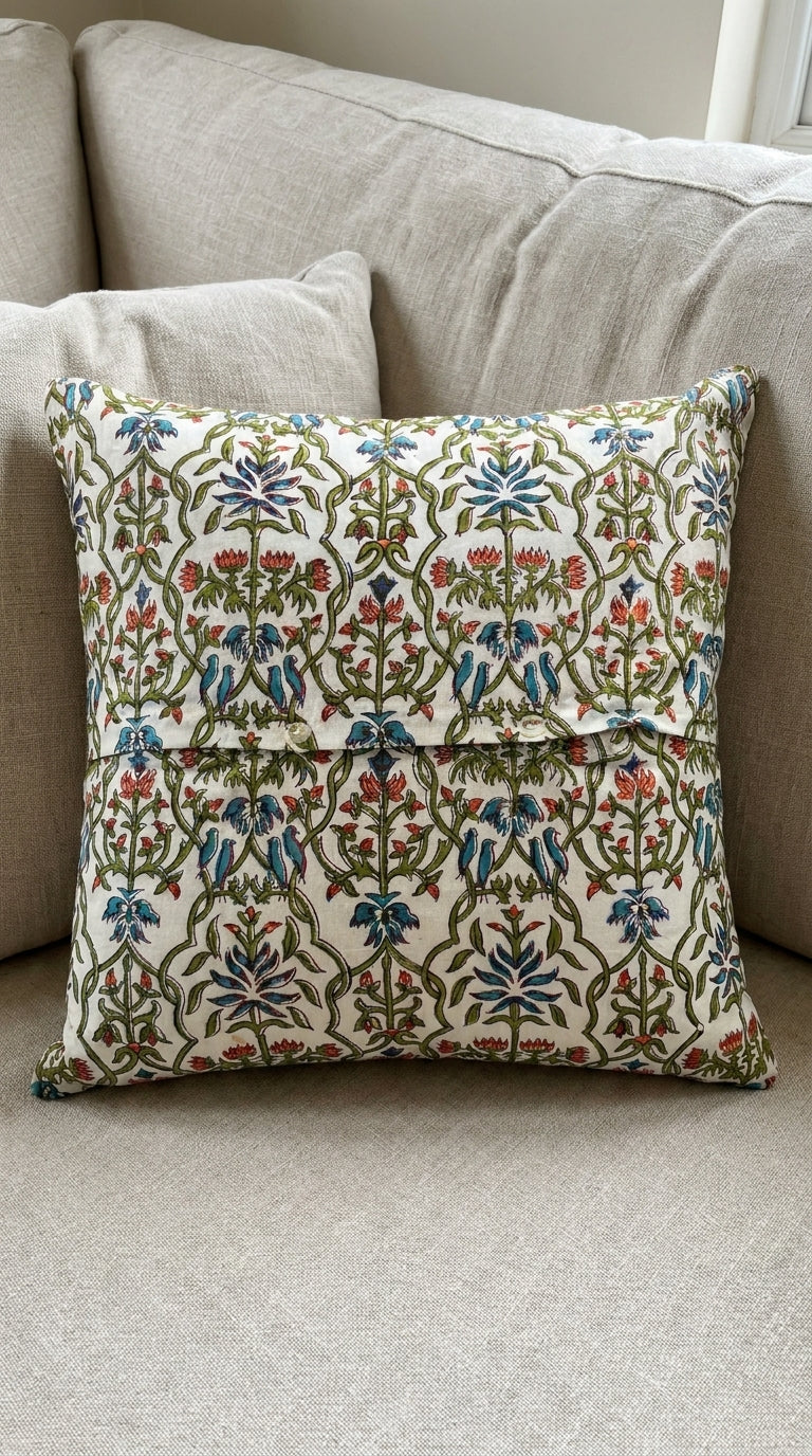 Close-up of hand block printed cotton cushion cover showing bluebird and botanical trellis pattern