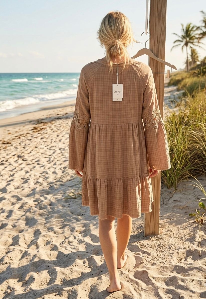 Back view of mocha plaid cotton tiered dress showing crochet lace bell sleeve detail, styled on a tropical beach — Luxmee Global Fashion